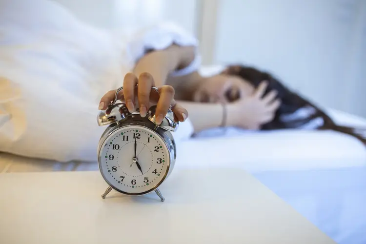 Woman lying in bed turning off an alarm clock in the morning at 5am. Hand turns off the alarm clock waking up at morning, girl turns off the alarm clock waking up in the morning from a call.

	stefanamer/getty images (stefanamer/Getty Images)
