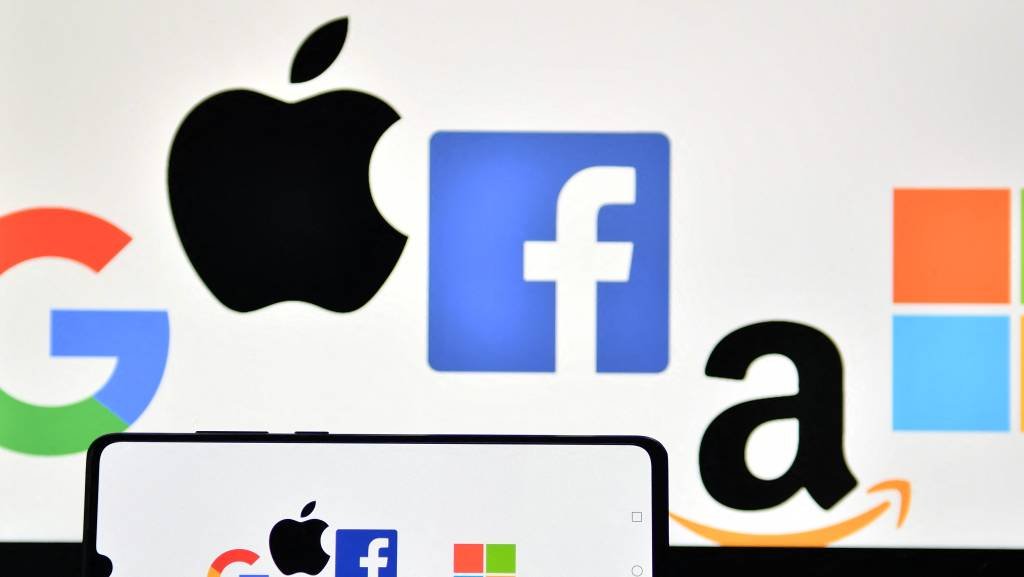 An illustration picture taken in London on December 18, 2020 shows the logos of Google, Apple, Facebook, Amazon and Microsoft displayed on a mobile phone and a laptop screen. - The European Union on December 15 unveiled tough draft rules targeting tech giants like Google, Amazon and Facebook, whose power Brussels sees as a threat to competition and even democracy. (Photo by JUSTIN TALLIS / AFP) (Photo by JUSTIN TALLIS/AFP via Getty Images) (JUSTIN TALLIS/AFP/Getty Images)