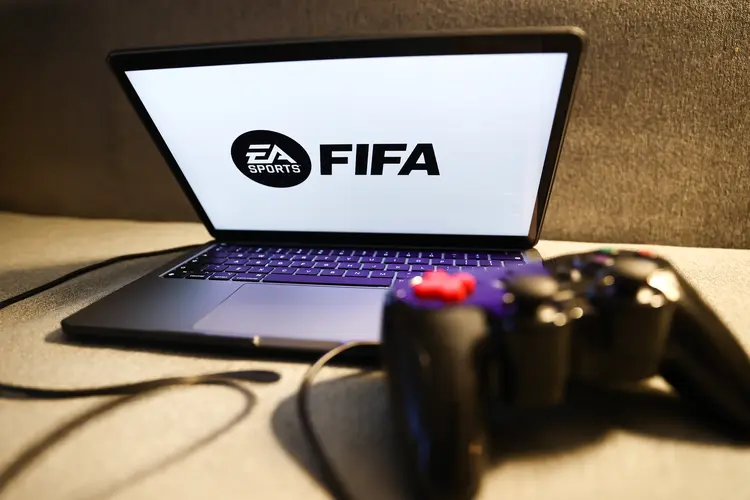 EA Sports FIFA logo displayed on a laptop screen and a gamepad are seen in this illustration photo taken in Krakow, Poland on August 23, 2022. (Photo by Jakub Porzycki/NurPhoto via Getty Images) (Jakub Porzycki/Getty Images)