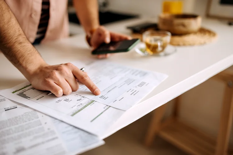 Unrecognisable man using calculator on the phone to calculate expenses (iStock/Getty Images)