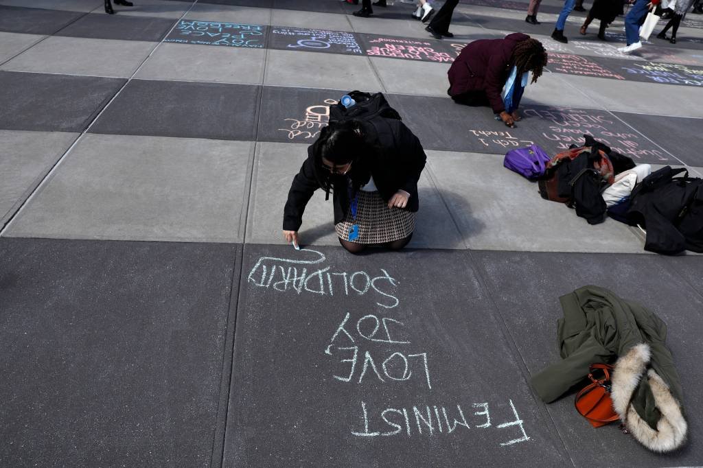 Joven escreve na calçada em frente ao prédio da ONU, em Nova York, onde acontece a reunião anual da CSW (ONU Mulheres/Divulgação)
