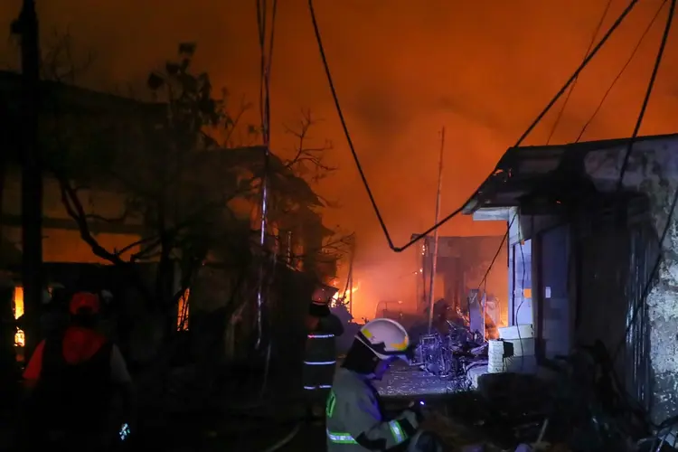 Bombeiros trabalham em área residencial próxima ao local do incêndio

 (AFP/AFP)