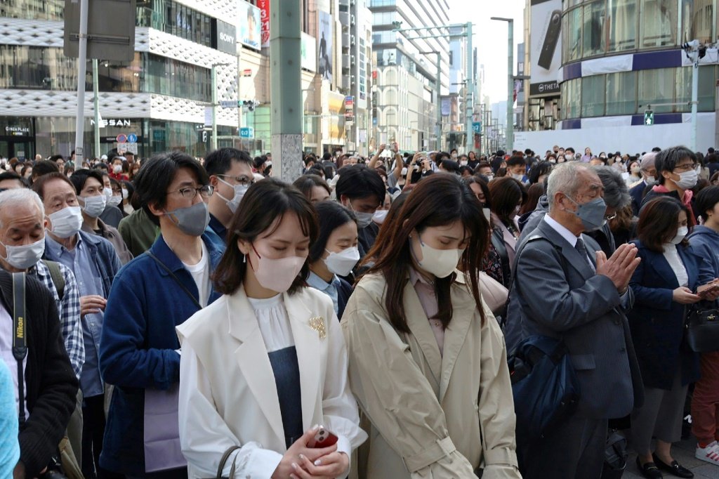 Várias pessoas em silêncio em Tóquio para recordar as vítimas do 12º aniversário do terremoto, tsunami e desastre nuclear de 2011. (AFP/AFP)