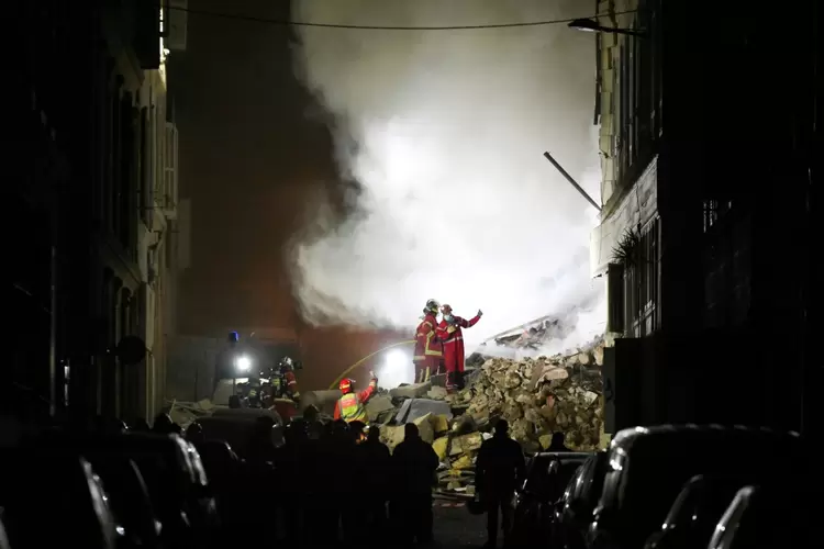 Resgatistas trabalham no lugar, onde um edifício caiu na cidade portuária de Marselha, no sul da França, em 9 de abril de 2023 (AFP/AFP)