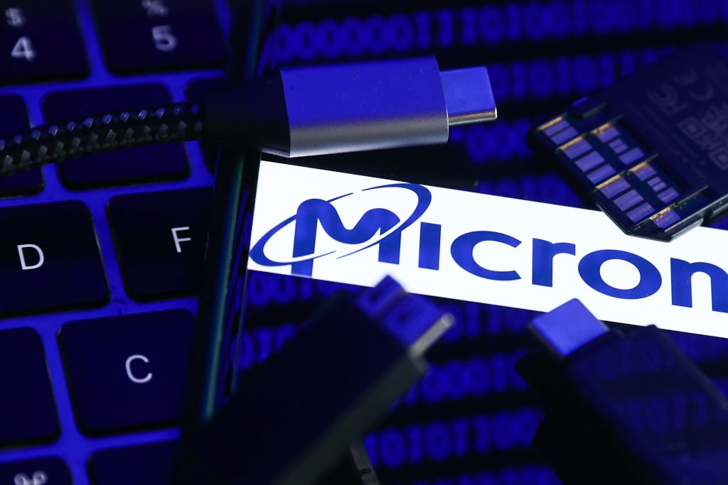 Micron logo displayed on a phone screen with a binary code reflected on it, a laptop keyboard, a memory card, an adaper and cables are seen in this illustration photo taken in Krakow, Poland on January 30, 2023. (Photo by Jakub Porzycki/NurPhoto via Getty Images) (Jakub Porzycki/Getty Images)