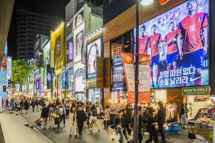 Nas ruas de Seul: população jovem caminha em frente a um shopping no bairro Myeong-dong (Maremagnum/Getty Images)