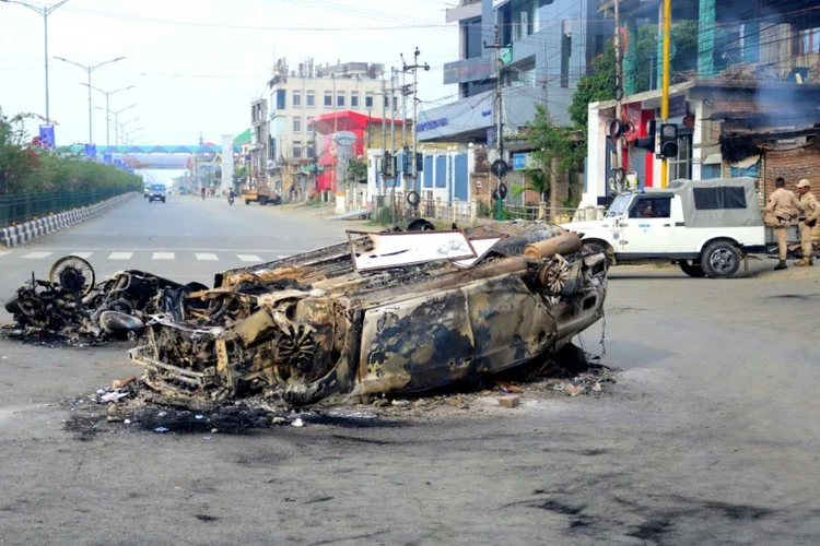 Veículos queimados nas ruas de Imphal, capital do estado indiano de Manipur (AFP/AFP Photo)