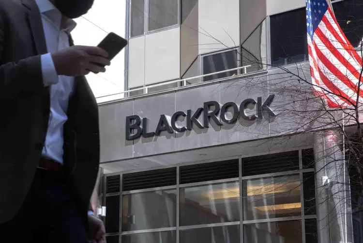 A pedestrian holding a smartphone passes in front of BlackRock Inc. headquarters in New York, U.S, on Tuesday, April 13, 2021. BlackRock Inc. is scheduled to release earnings figures on April 15. Photographer: Jeenah Moon/Bloomberg (Bloomberg/Bloomberg)