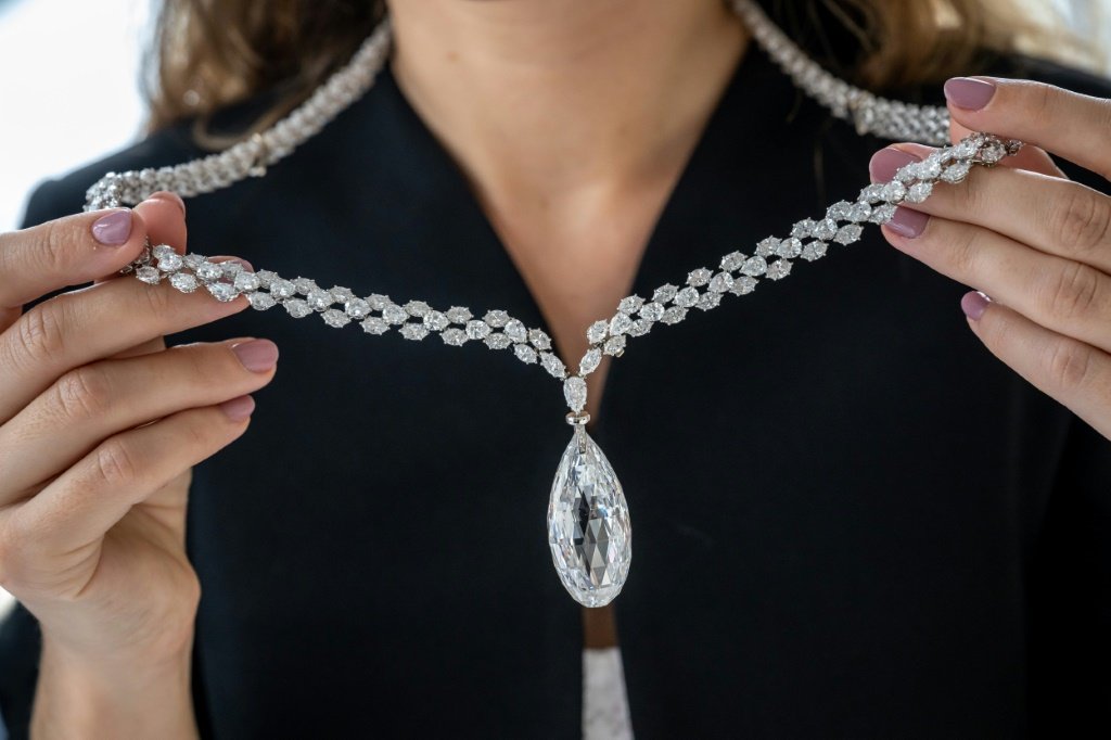 Funcionária da casa de leilões Christie's exibe um diamante incolor de 90,36 quilates, em um colar de diamantes, no leilão World of Heidi Horten, em Genebra (AFP/Reprodução)