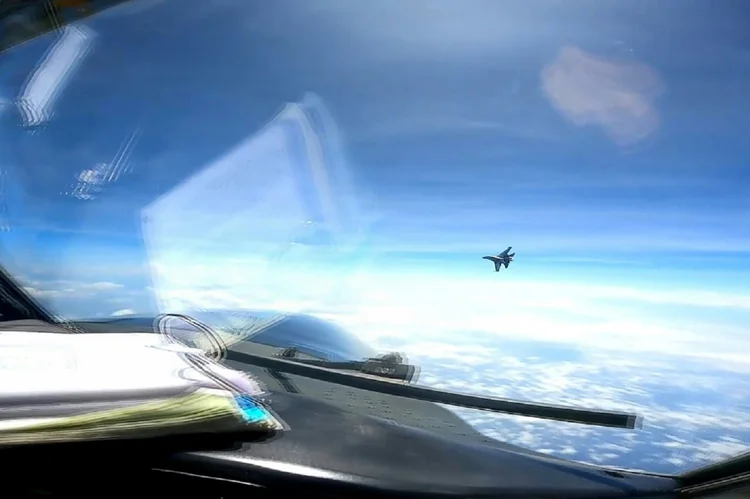 Um caça J-16 chinês voa em frente a um avião americano RC-135 sobre o Mar do Sul da China (AFP/AFP Photo)