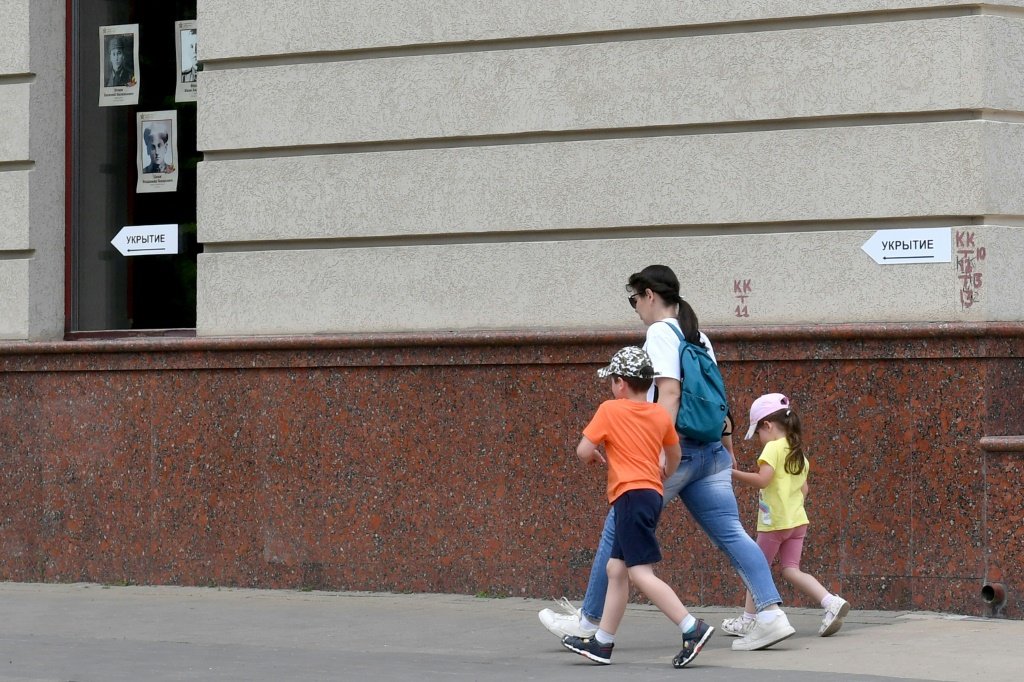 Mulher caminha com duas crianças na cidade russa de Belgorod, a cerca de 40 km da fronteira ucraniana, em 27 de maio de 2023 (AFP/AFP)