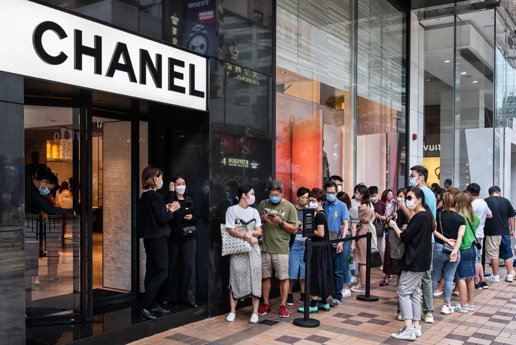 Consumidores aguardam em fila na entrada da loja da Chanel em Hong Kong  (Budrul Chukrut/SOPA Images/LightRocket/Getty Images)