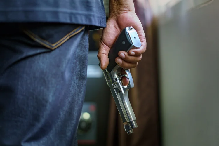 Man carrying a gun to rob the money. (Natnan Srisuwan/Getty Images)