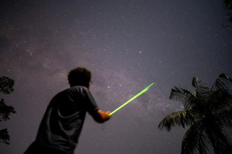 Daniel Mello, astrônomo do Observatório do Valongo da Universidade Federal do Rio de Janeiro (UFRJ), mostra a Via Láctea com laser durante observação noturna no Parque do Desengano, em Santa Maria Madalena, interior do Rio de Janeiro (AFP/AFP)