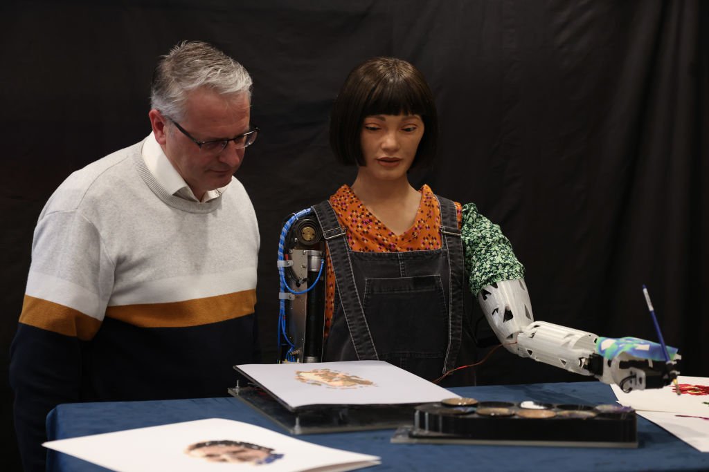 Aidan Meller olha para uma pintura de Ai-Da Robot, um artista robô humanóide ultrarrealista, durante uma coletiva de imprensa na Biblioteca Britânica em 4 de abril de 2022 em Londres, Inglaterra.  (Hollie Adams/Getty Images)