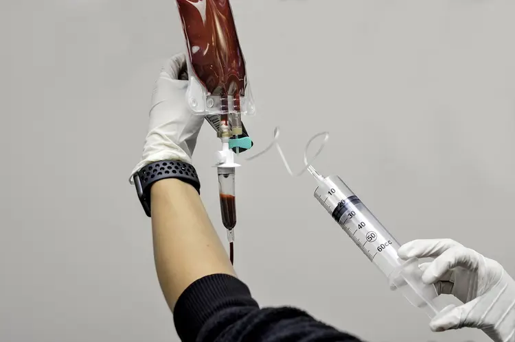 A nurse injects a syringe of ozone into an IV bag full of the patients blood. Once all the ozone is in the blood will be dripped back into the patient intravenously. (James Mutter/Getty Images)