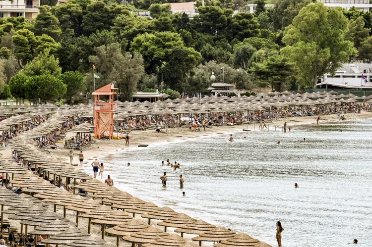 Praia Oceanis, coberta de barracas,em Vouliagmeni, 25 km ao sul de Atenas, em 13 de agosto de 2023 (AFP/AFP)