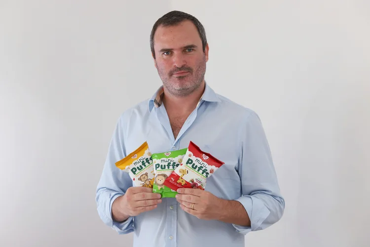 O empresário Daniel Goldstein segurando snacks naturais da sua empresa, a Nhami Mami (Nhami Mami/Divulgação)