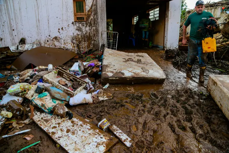 Homem tenta recuperar seus pertences após ciclone em Muçum (SILVIO AVILA/Getty Images)