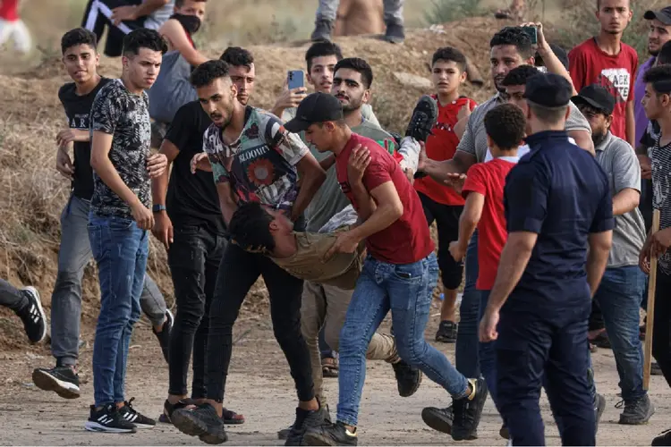 Corpo sendo carregado na Faixa de Gaza: exército de Israel retoma ataques aéreos (Agence France-Presse/AFP Photo)
