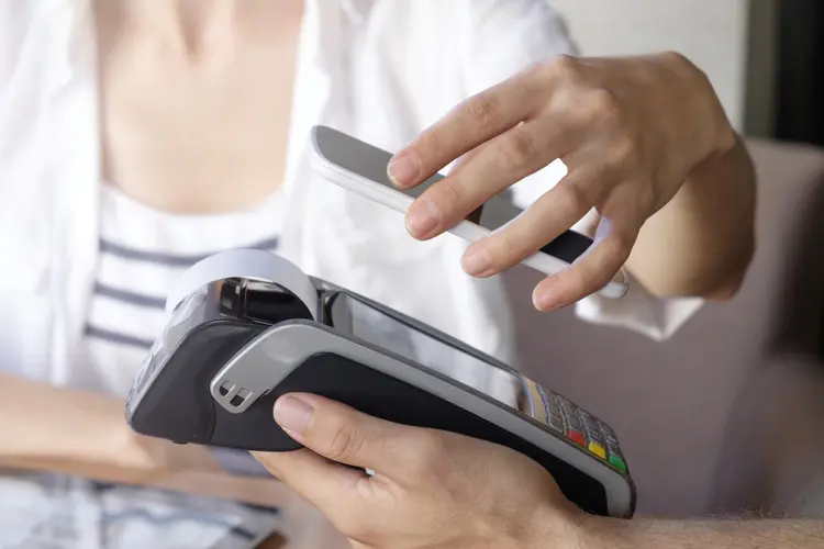 Cropped shot of a customer paying using a smart phone and an electronic reader.