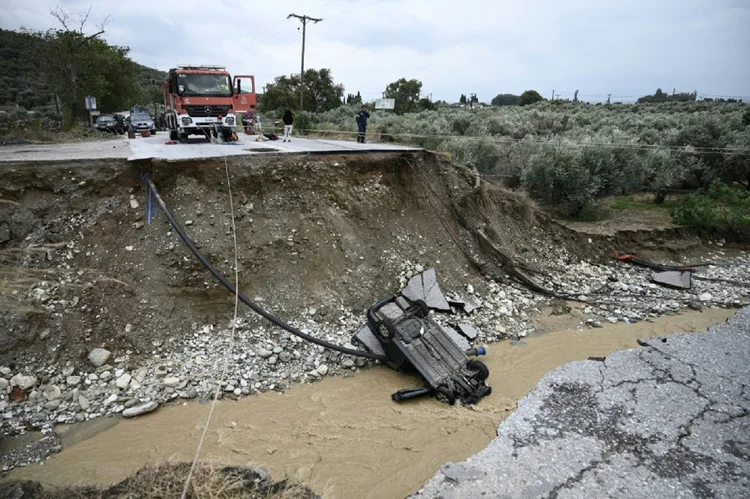Um veículo arrastado por um desabamento de estrada devido a uma enchente perto da cidade de Volos, no centro da Grécia, em 6 de setembro de 2023 (AFP/AFP Photo)