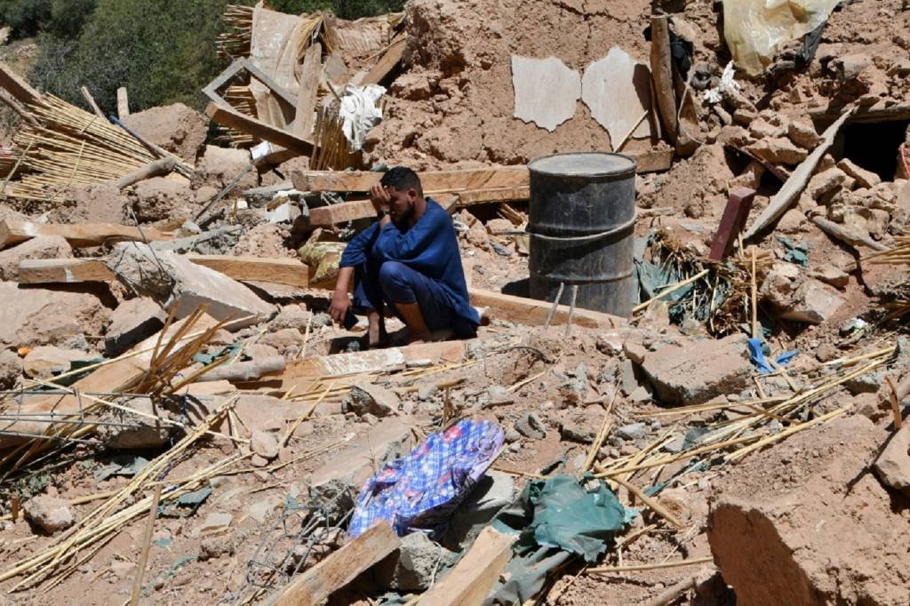 Homem chora sobre os escombros de uma casa em Tikht, sudoeste do Marrocos (Joshua MELVIN/AFP Photo)