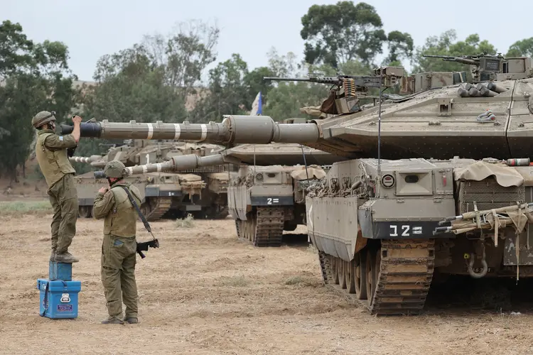 Soldados do exército israelense estão posicionados com seus tanques Merkava perto da fronteira com a Faixa de Gaza (JACK GUEZ /AFP)
