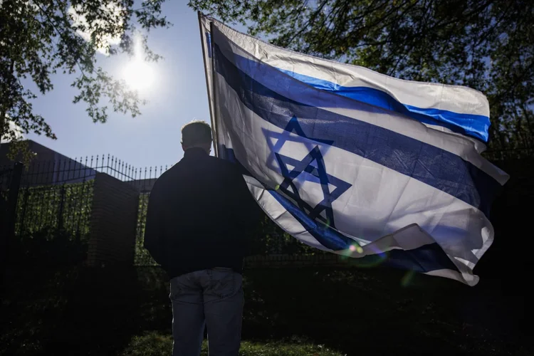 Homem carrega duas bandeiras israelenses durante uma manifestação pró-Israel nos EUA: decisão da suprema corte pode ter efeitos políticos significativos no país (Samuel Corum / GETTY IMAGES NORTH AMERICA / Getty Images/AFP)