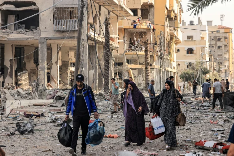 Palestinos fogem com seus pertences da cidade de Gaza (AFP/AFP)