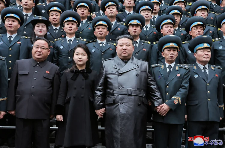 This picture taken on November 23, 2023 and released from North Korea's official Korean Central News Agency (KCNA) on November 24, 2023 shows North Korea's leader Kim Jong Un (C) and his daughter (2nd L-front) posing with scientists who contributed to the launch of a reconnaissance satellite, at the National Aerospace Technology Directorate in Pyongyang. North Korea said on November 23 it would deploy new weapons and stronger armed forces to the border with the South, as Seoul's spy agency said Pyongyang had received Russian help to successfully put a military spy satellite into orbit. (Photo by KCNA VIA KNS / AFP) / South Korea OUT / REPUBLIC OF KOREA OUT
---EDITORS NOTE--- RESTRICTED TO EDITORIAL USE - MANDATORY CREDIT "AFP PHOTO/KCNA VIA KNS" - NO MARKETING NO ADVERTISING CAMPAIGNS - DISTRIBUTED AS A SERVICE TO CLIENTS / THIS PICTURE WAS MADE AVAILABLE BY A THIRD PARTY. AFP CAN NOT INDEPENDENTLY VERIFY THE AUTHENTICITY, LOCATION, DATE AND CONTENT OF THIS IMAGE --- / (AFP/AFP Photo)