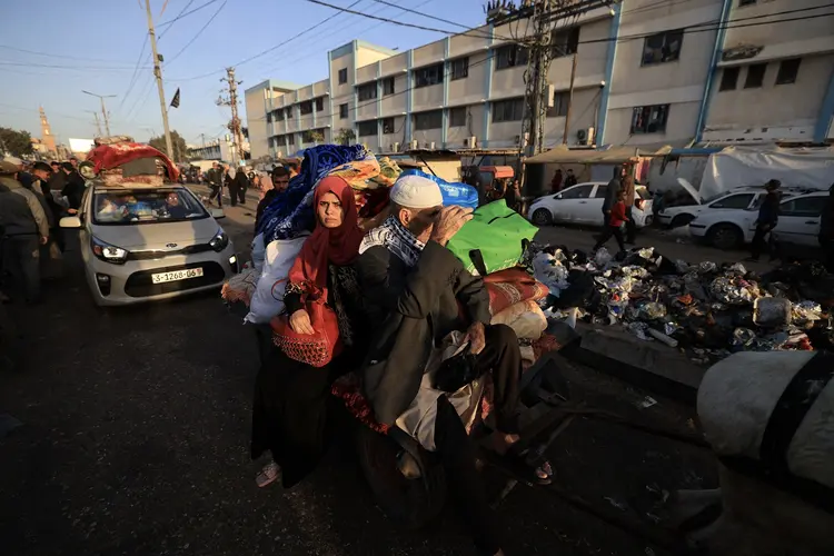 Palestinos que se refugiaram em abrigos temporários retornam às suas casas no leste de Khan Yunis, no sul da Faixa de Gaza, durante as primeiras horas de uma trégua de quatro dias nas batalhas entre Israel e militantes do Hamas, em 24 de novembro de 2023 (Mahmud HAMS/AFP)
