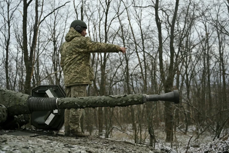 Militar ucraniano se posiciona no topo de um veículo blindado na direção de Bakhmut, na região de Donetsk (Khrystyna Zanyk/AFP Photo)