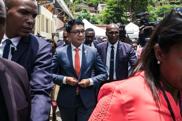 Andry Rajoelina aperta um botão ao chegar ao anúncio dos resultados provisórios do primeiro turno das eleições presidenciais de Madagascar. (AFP/AFP Photo)