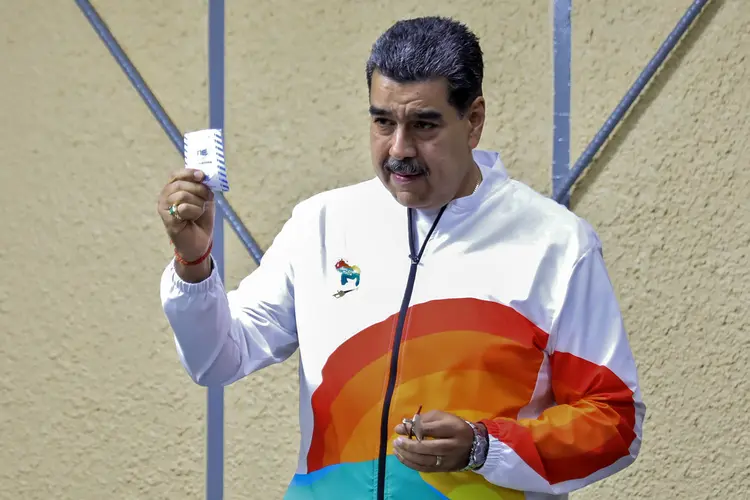 Nicolás Maduro, presidente da Venezuela, mostra cédula ao votar em plebiscito em 3 de dezembro de 2023 (Marcelo Garcia/AFP)