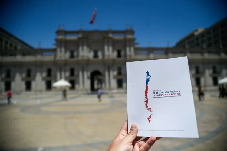 Um exemplar da proposta de nova Constituição chilena em frente ao Palácio presidencial de La Moneda, em 12 de dezembro de 2023 (Paulina Abramovich/AFP Photo)