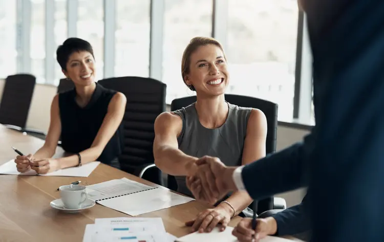 Handshake, meeting and business women partnership for b2b collaboration, onboarding welcome or professional interview. Happy corporate people or clients shake hands for deal in office conference room (Divulgação / Getty Images)