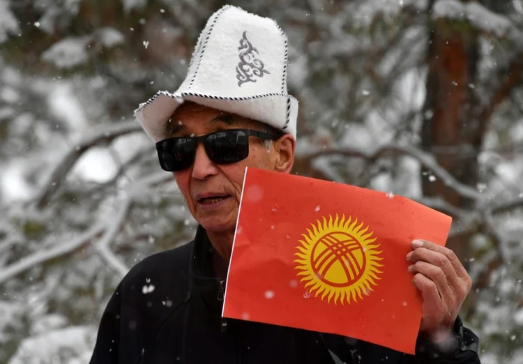 Manifestante protesta contra mudança da bandeira nacional quirquiz, em Bishkek, em 9 de dezembro de 2023 (Agence France-Presse/AFP Photo)