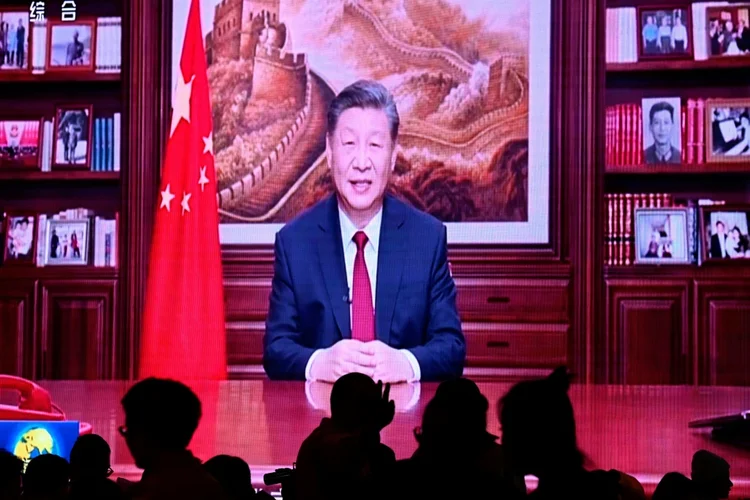 Pessoas jantam em um restaurante enquanto assistem ao discuso televisionado de Ano Novo do presidente chinês Xi Jinping em Pequim, em 31 de dezembro 2023 (Agence France-Presse/AFP)