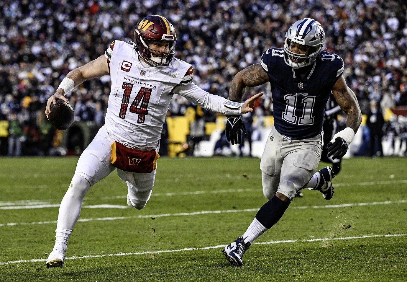 LANDOVER, MD - JANUARY 07: Washington Commanders quarterback Sam Howell (14) avoids the tackle of Dallas Cowboys linebacker Micah Parsons (11) during the NFL game between the Dallas Cowboys and the Washington Commanders on January 7, 2024 at Fed Ex Field in Landover, MD. (Photo by Mark Goldman/Icon Sportswire via Getty Images)