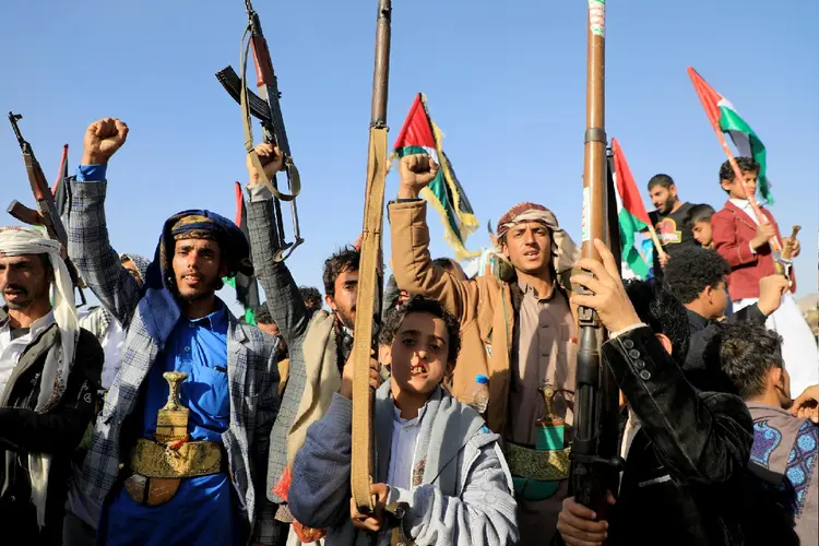 Manifestantes iemenitas exibem suas armas durante um protesto contra os bombardeios britânico-americanos, em Saná (Mohammed Huwais/Getty Images)