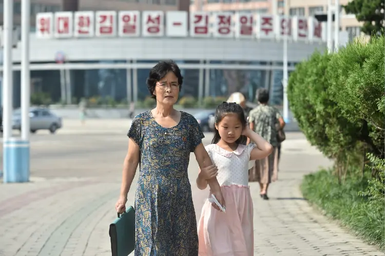 Coreia do Norte: mãe e filha caminhando em praça de Pyongyang (Kim Won Jin/Getty Images)