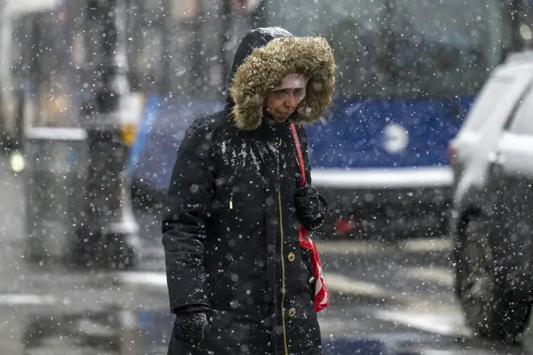 Mulher caminha sob intensa nevasca na cidade de Nova York, em 19 de janeiro de 2024 (AFP/AFP)