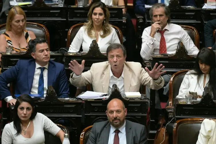 Oscar Zago (centro), deputado do partido governista Liberdade Avança, fala no Congresso argentino antes da votação das reformas ultraliberais do presidente Javier Milei (AFP Photo)