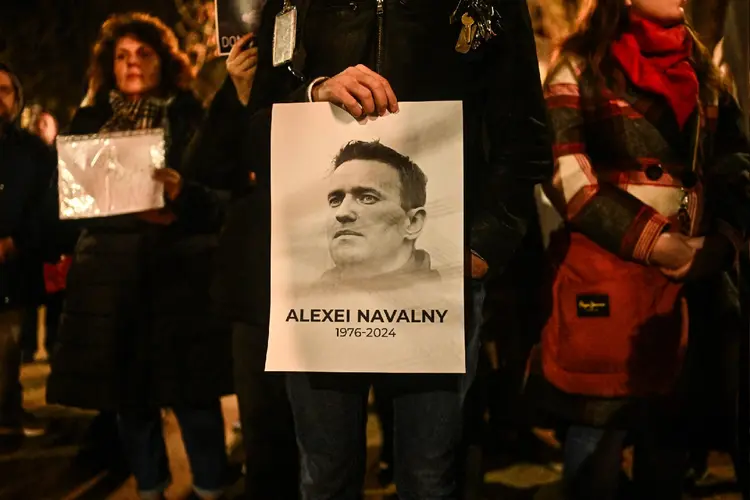 Apoiadores do falecido líder da oposição russa, Alexei Navalny, seguram faixas e colocam velas ao redor de um memorial improvisado (Omar Marques/Getty Images)