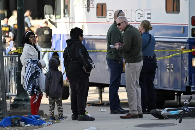 Policiais falam com uma família após os tiros registrados no desfile do Super Bowl no Kansas, Missouri, Estados Unidos (AFP Photo)