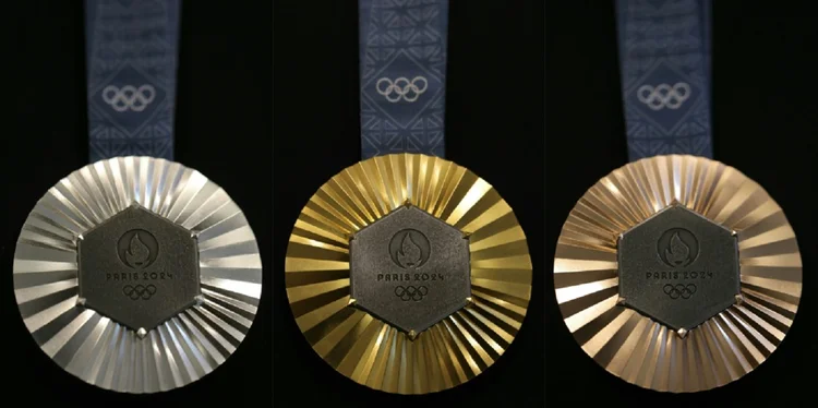 A frente das medalhas é decorada com um hexágono de ferro procedente da Torre Eiffel e com o logotipo Paris-2024, de onde emanam raios gravados no metal da medalha