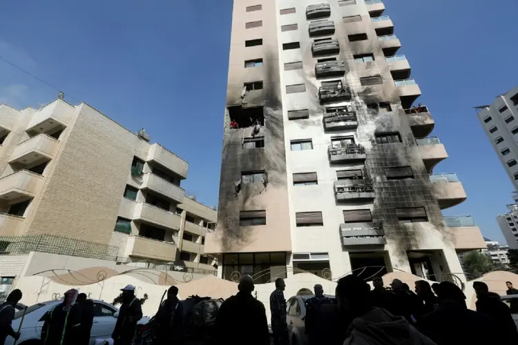 A agência estatal SANA publicou imagens das supostas consequências do ataque em que se vê um edifício de vários andares com fachada escurecida e janelas quebradas (AFP/AFP)