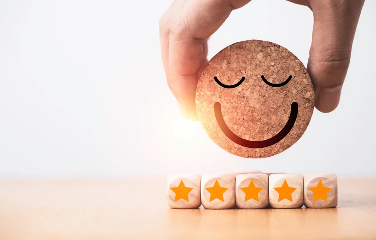 Hand holding circle smile face with five stars for customer client evaluation after use product and service concept.