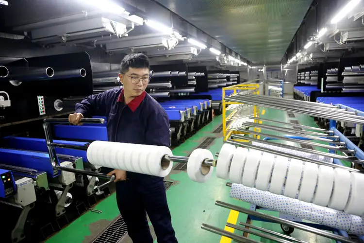 A worker is producing textile foreign trade products on a workshop production line at a spandex company workshop in the Lianyungang Economic and Technological Development Zone, Jiangsu Province, China, on March 18, 2024. (Photo by Costfoto/NurPhoto via Getty Images) (Costfoto/NurPhoto/Getty Images)
